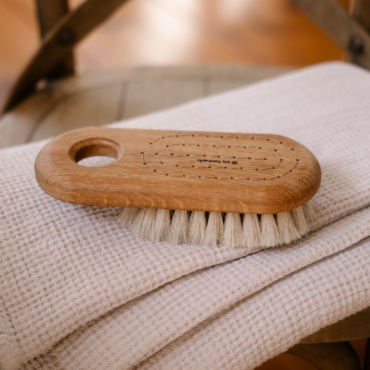 A Body Brush - Firm from Iris Hantverk sits on top of a white towel.
