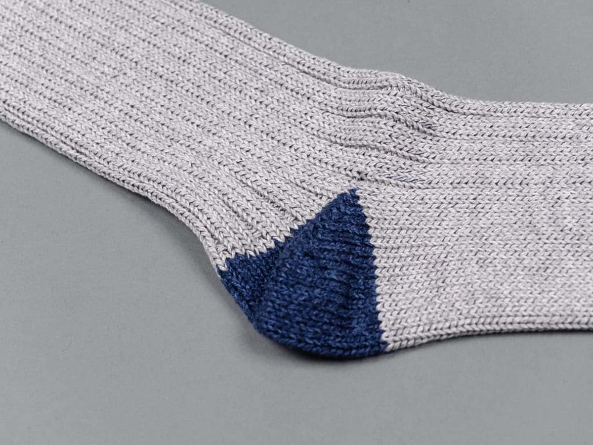 A pair of Nishiguchi Kutsushita Boston Slab Socks - Grey Denim on a grey surface.
