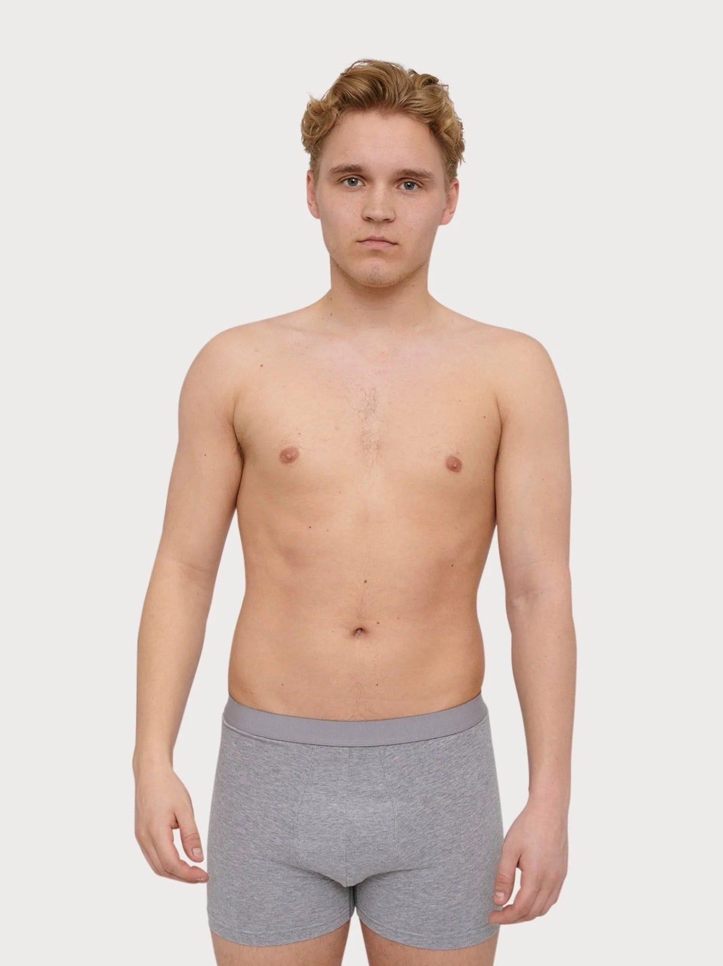 A young man in Organic Basics' Boxers - Organic Cotton (2-pack) - Grey Melange.