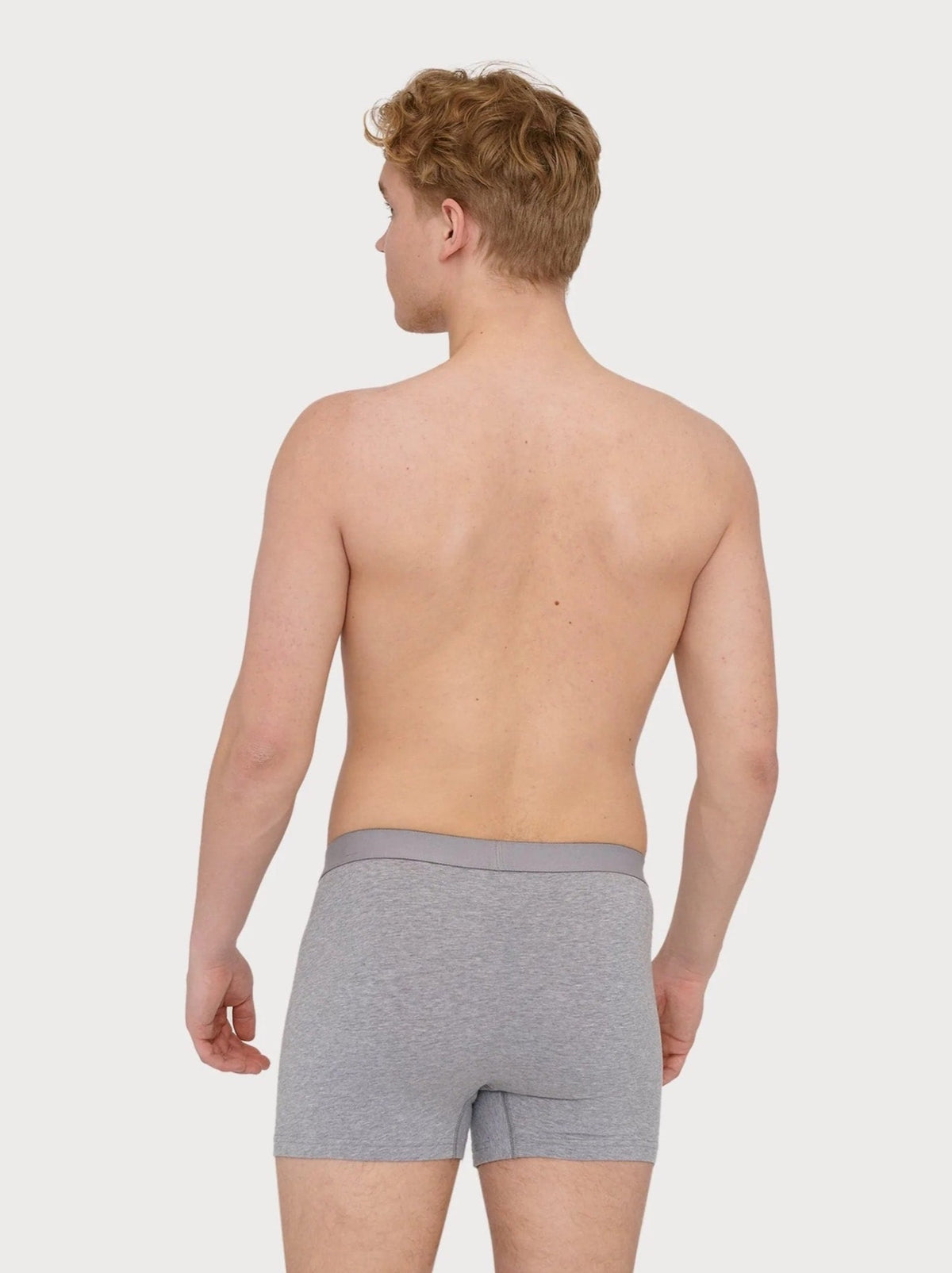 The back view of a man in Organic Basics&#39; Boxers - Organic Cotton (2-pack) - Grey Melange.