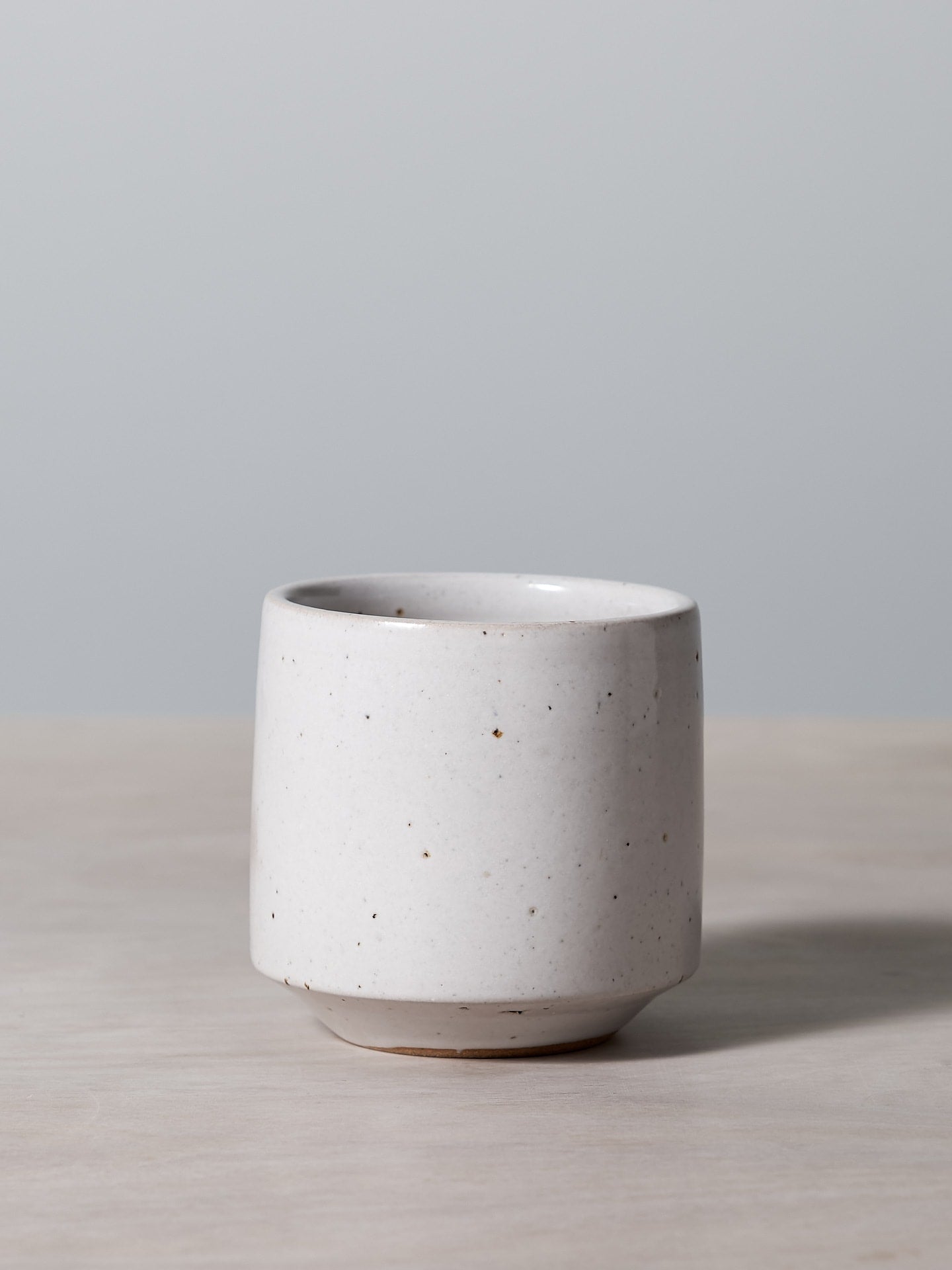 A Richard Beauchamp Stacking Tumbler sitting on a wooden table.