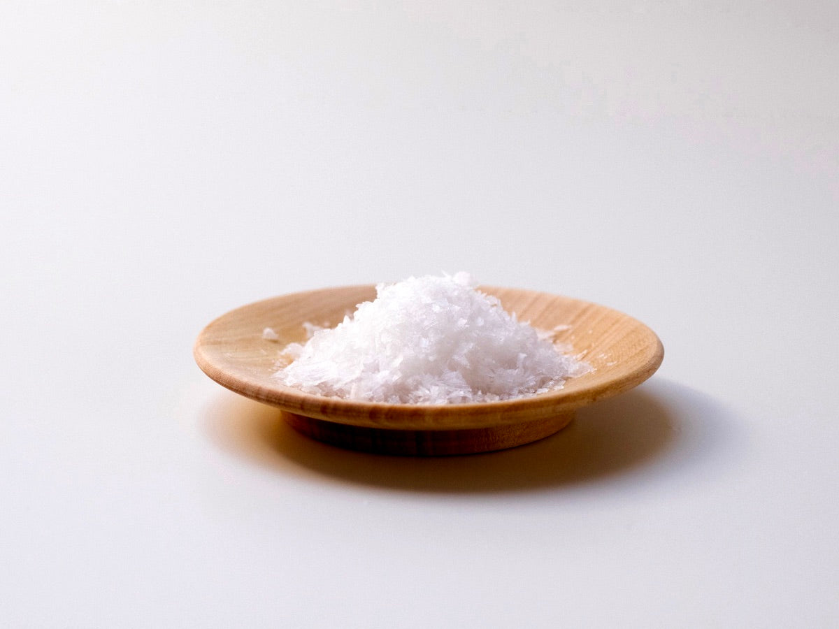 White salt in an Iris Hantverk Wooden Plate – Small on a white background.