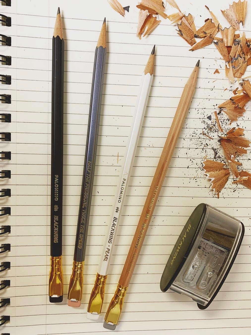 Blackwing Natural Pencils and a Palomino Blackwing pencil sharpener on a notebook.