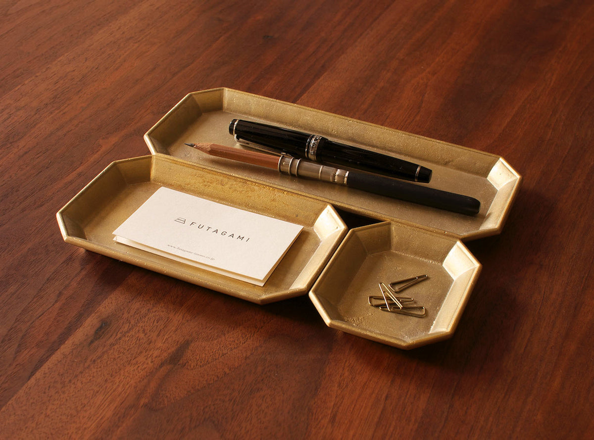 A Futagami Stationery Tray - Solid Brass with a pen and a pen holder.