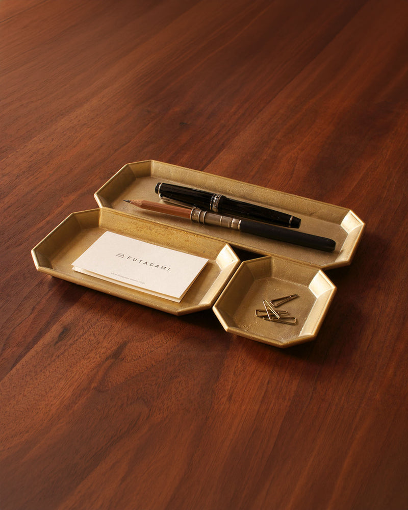 A Futagami Stationery Tray - Solid Brass with a pen and a pen holder.