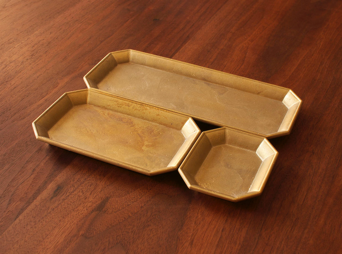Three Futagami Stationery Trays – Solid Brass on a wooden table.