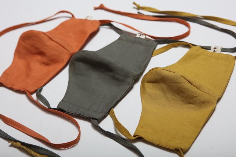 Three different colored Linen Face Masks - Citrus by Peppin on a white surface.