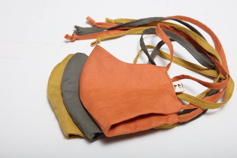 A pair of Linen Face Masks - Citrus by Peppin on a white surface.