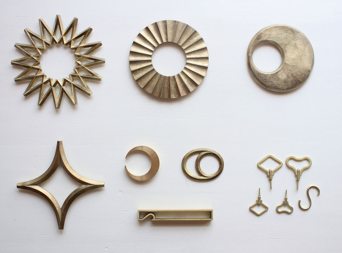 A variety of Futagami Moon Trivet – Solid Brass items arranged on a white surface.
